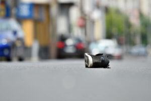 Shoe on the street with cars in background after victim was hit by vehicle